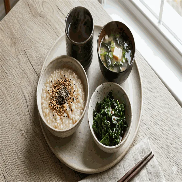 Macrobiotic morning plate with miso soup, brown rice porridge, steamed kale and bancha tea